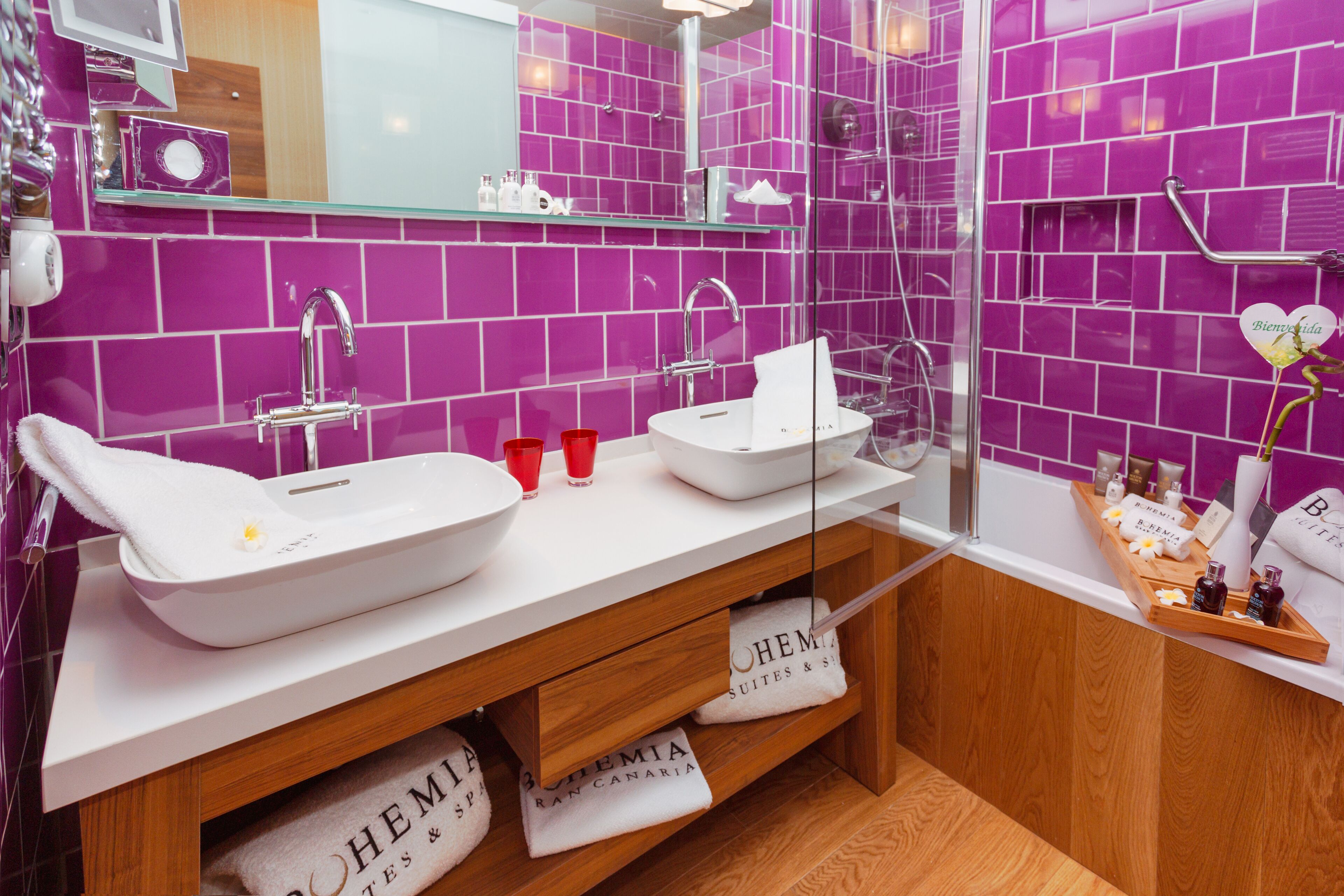 A modern bathroom with two sinks, a bathtub, and a shower.