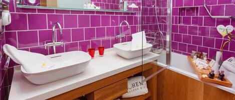 A modern bathroom with two sinks, a bathtub, and a shower.