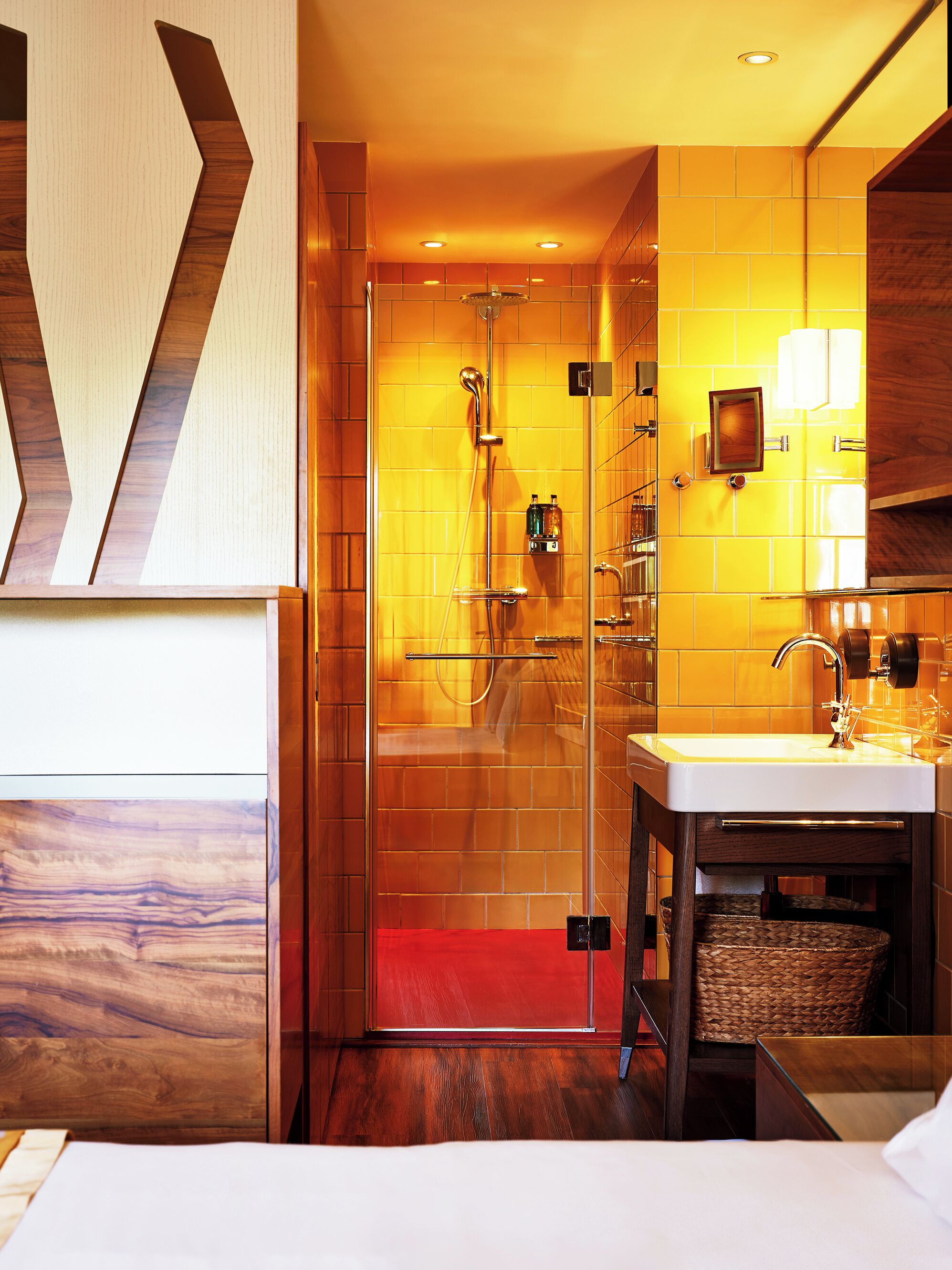 A modern bathroom with a glass shower enclosure, a sink, and a mirror.