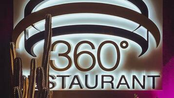 Segnaletica per ristorante panoramico a 360°, con design circolare e lettere illuminate.