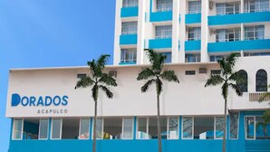 A Dorados building with a stone facade, blue accents, and palm trees in front. - Dorados Acapulco (Acapulco)