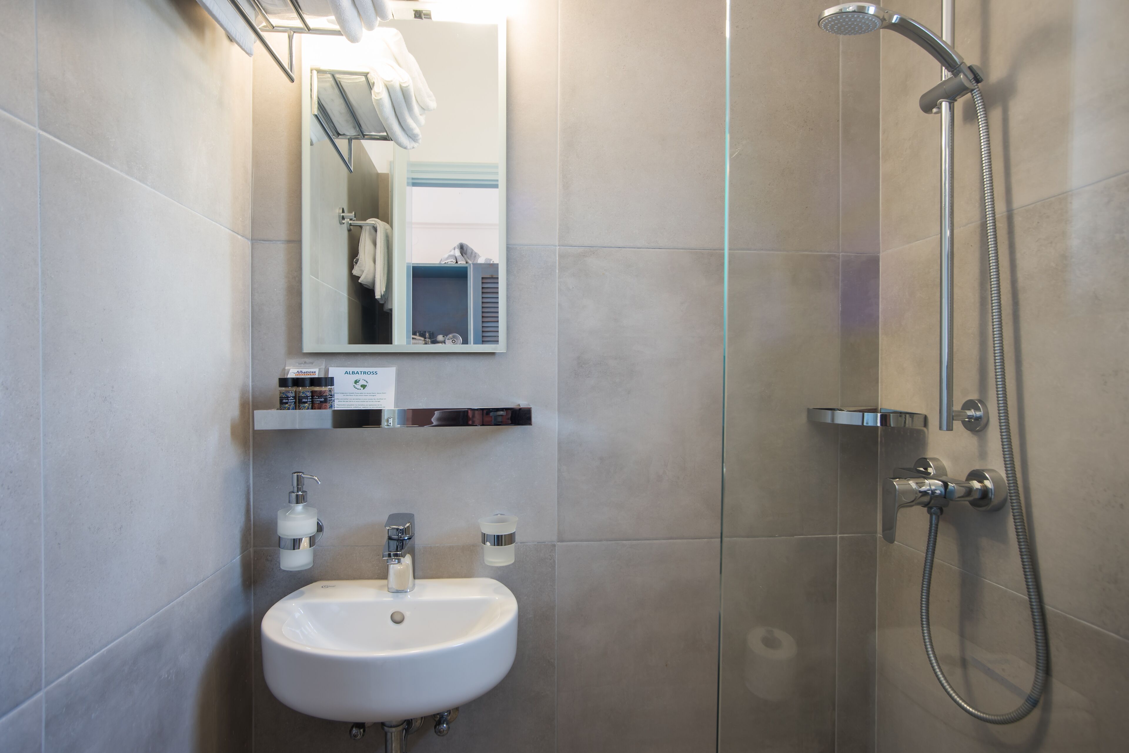 A modern bathroom with a sink, mirror, and shower.