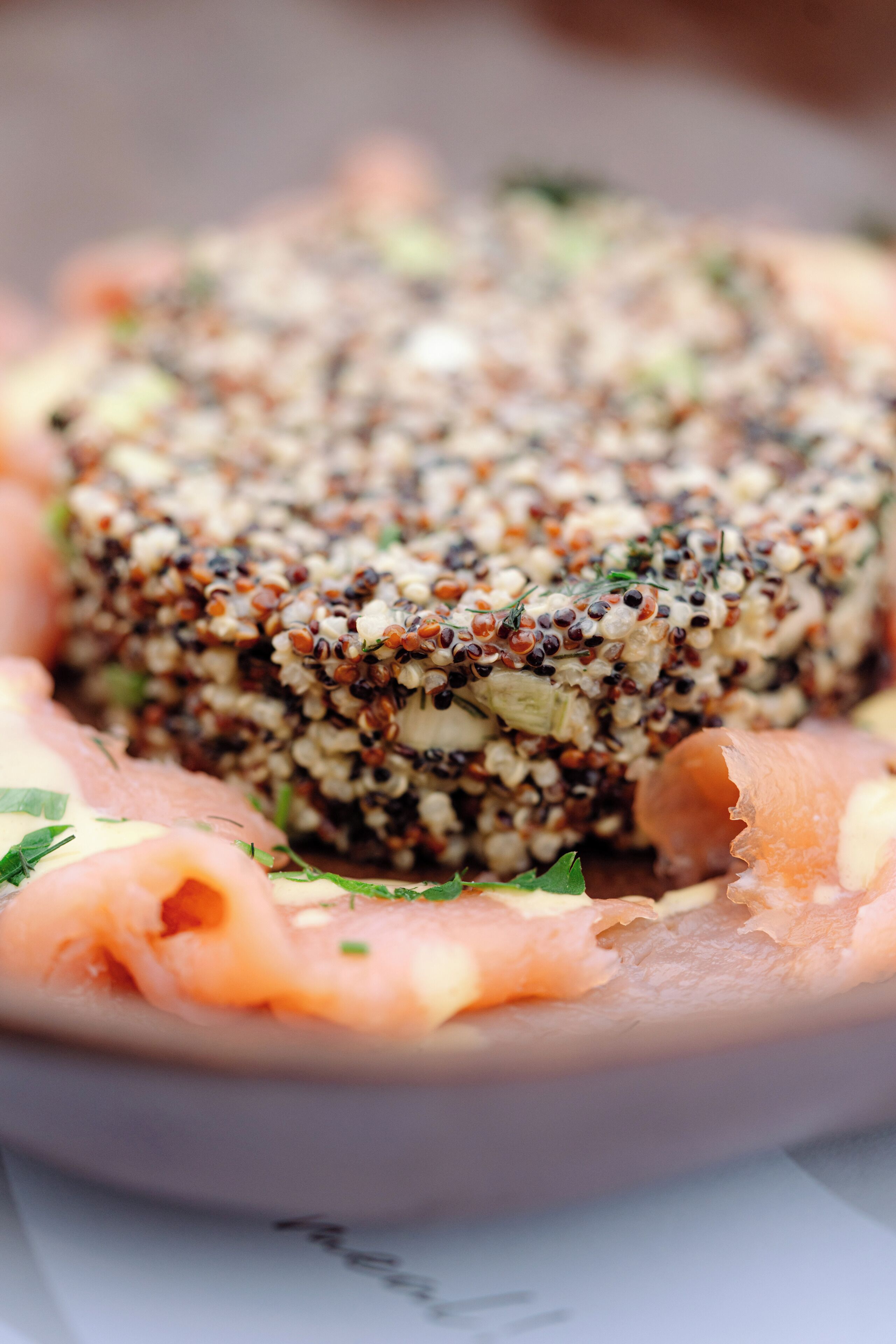 En ret med quinoa og laks, pyntet med krydderurter.