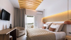 A bedroom with a bed, a desk, a chair, a TV, and a balcony.