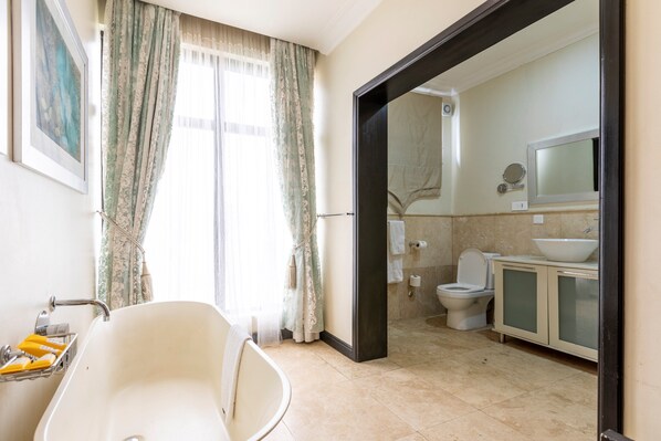 A bathroom with a bathtub, toilet, and sink, with a mirror above the sink.
