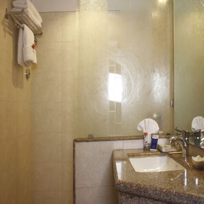 A bathroom with a sink, mirror, and towel rack.