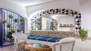 A seating area with a patterned bench, two chairs, and a small round table. - Hotel Hacienda Vallarta Playa Las Glorias (Puerto Vallarta)