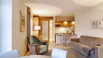 Ein modernes Wohnzimmer mit Sofa, Sessel und Essbereich.