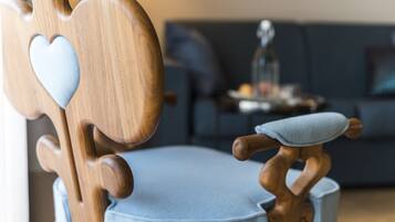 A wooden chair with a heart-shaped cutout and a cushion.