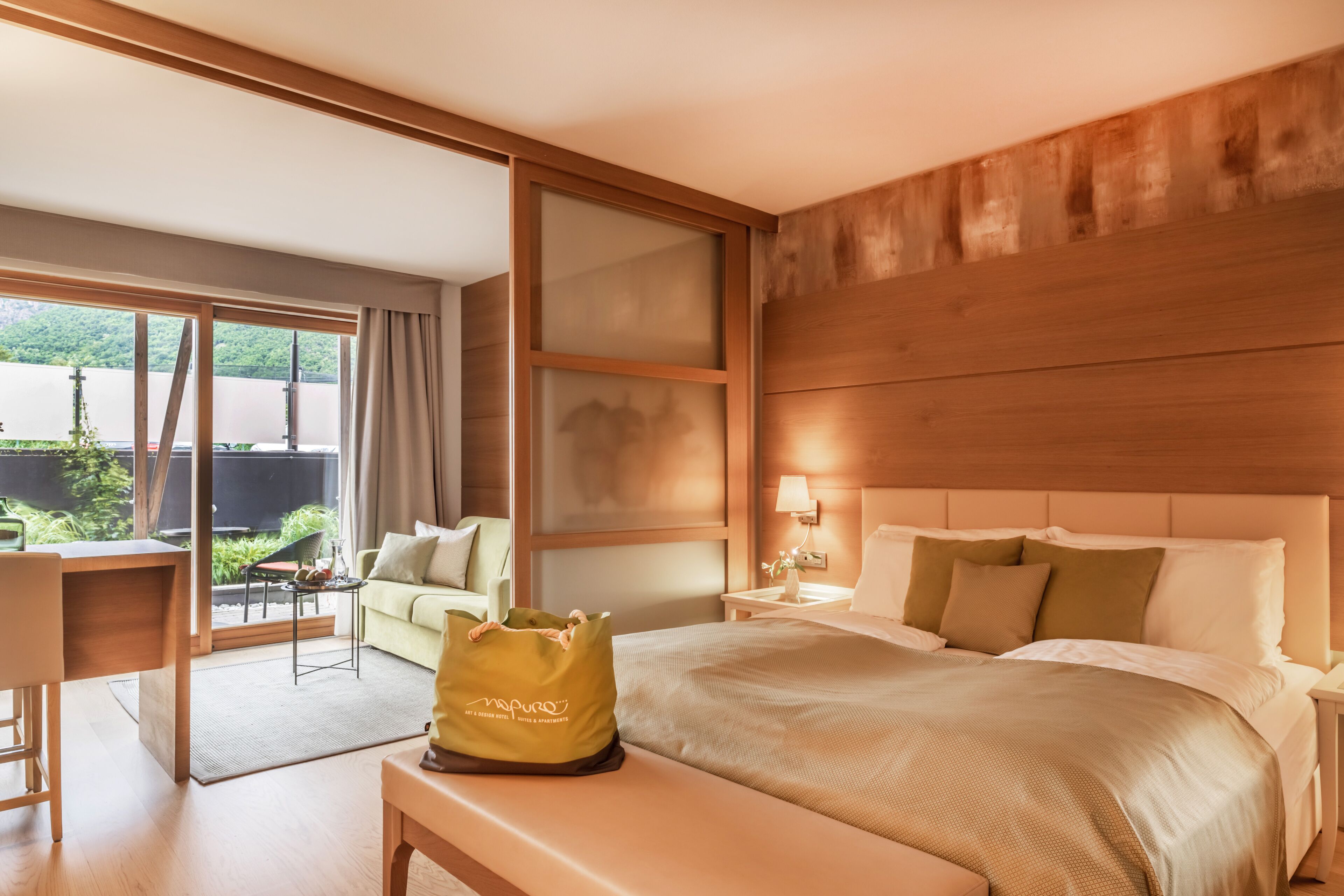 Habitación de hotel con una cama grande, un escritorio, una silla y vistas a zonas verdes.