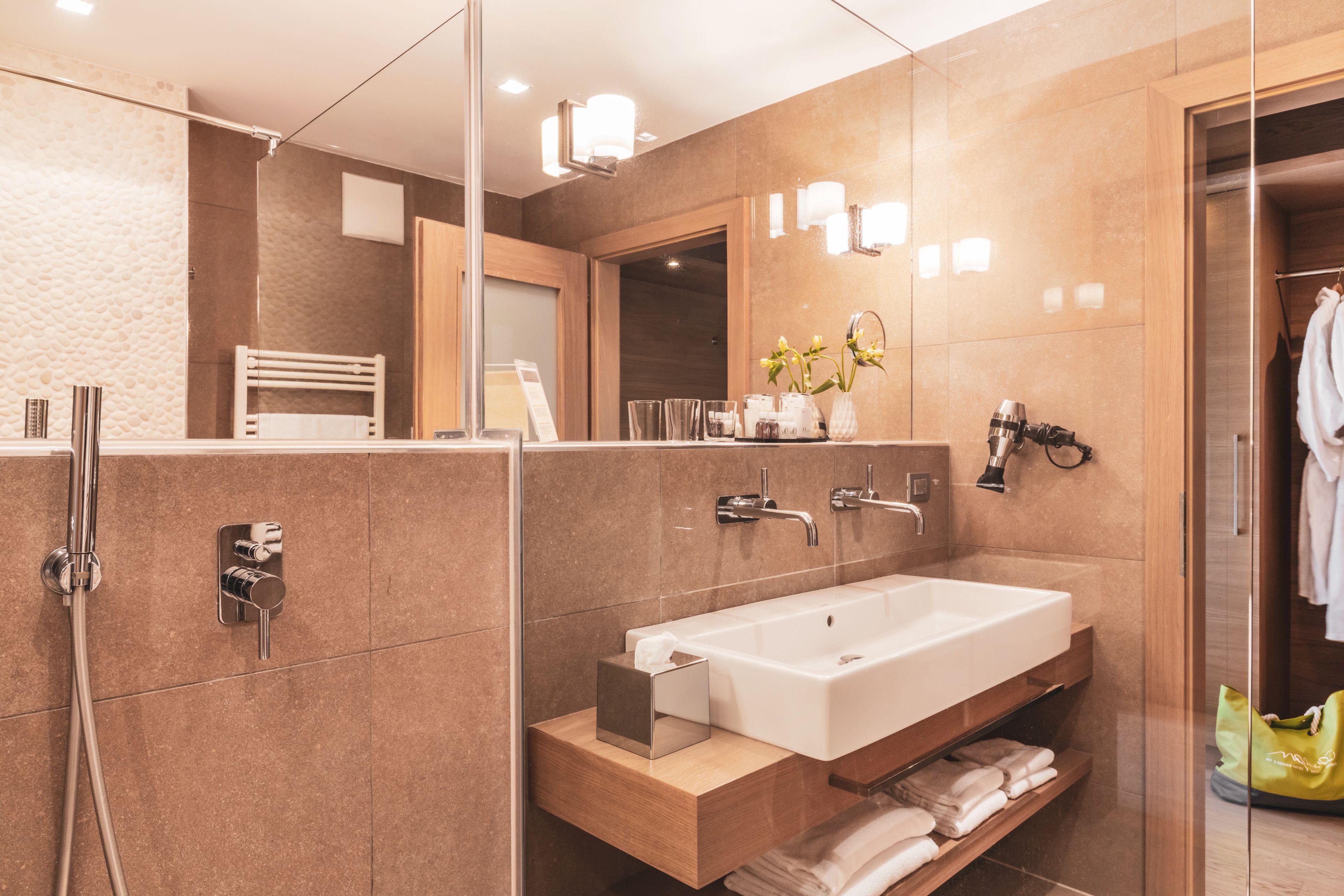 Ein modernes Badezimmer mit einem großen Waschbecken, Spiegel und Handtuchhalter.