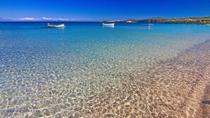 A clear beach with boats and a distant hilly landscape. - Colonides Beach Hotel (Pylos-Nestoras)
