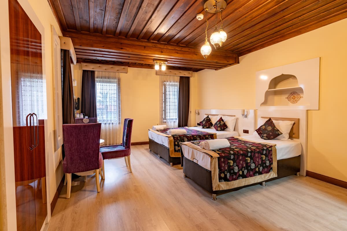 Deluxe driepersoonskamer | Luxe beddengoed, een kluis op de kamer, een bureau