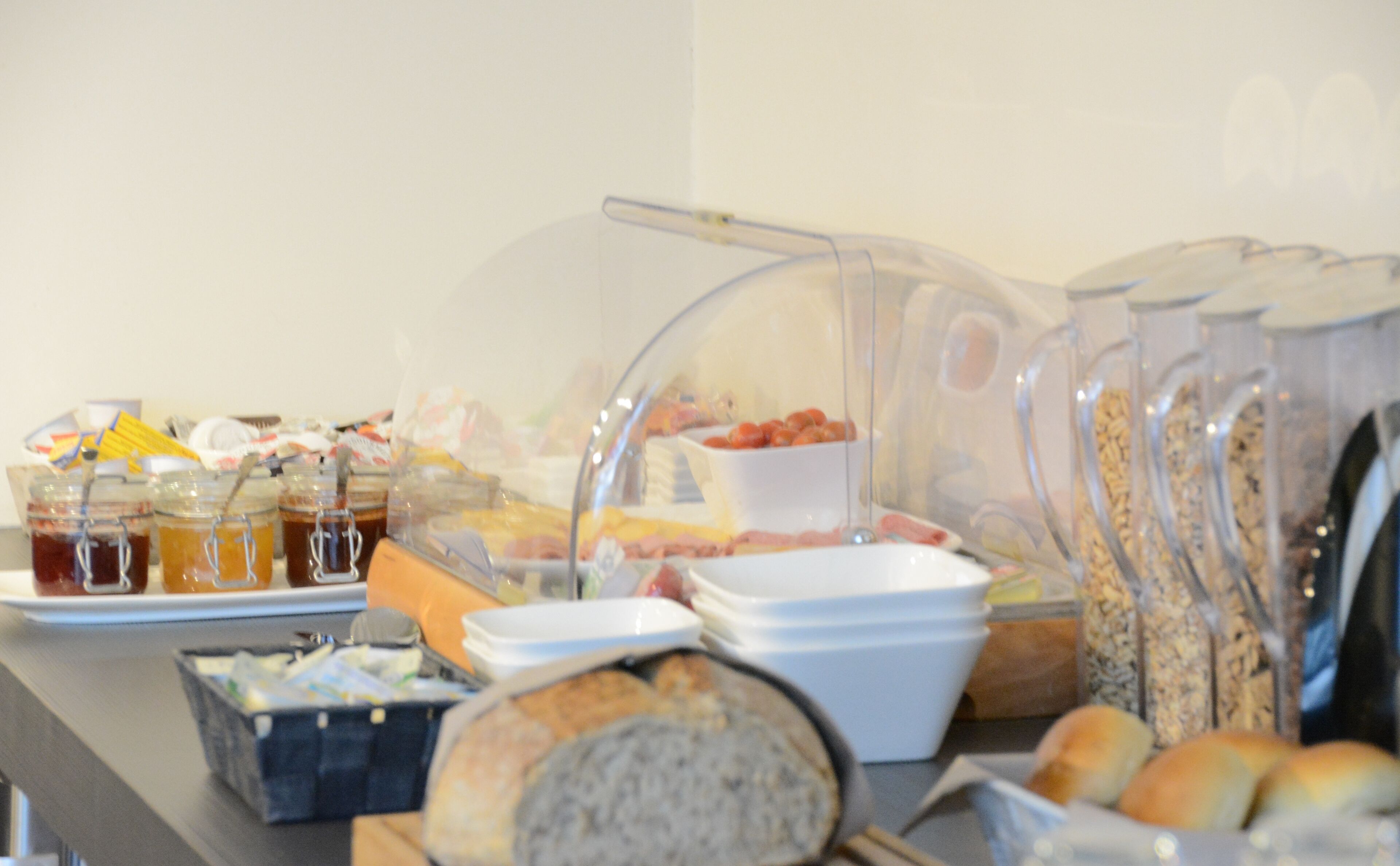 Un buffet proposant une variété de plats, notamment du pain, des pâtisseries et des condiments.