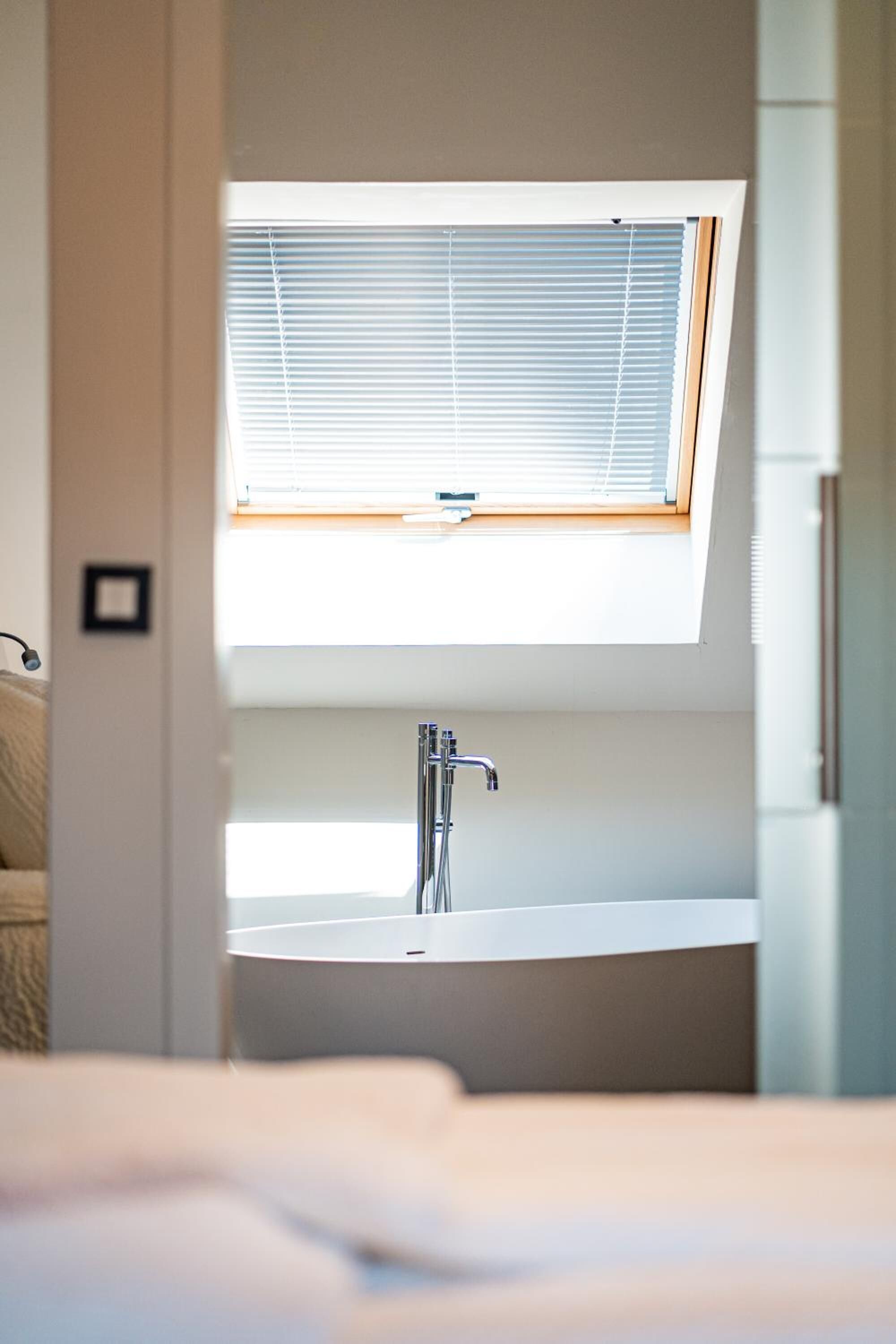 A modern bathroom with a skylight, a sink, and a toilet.