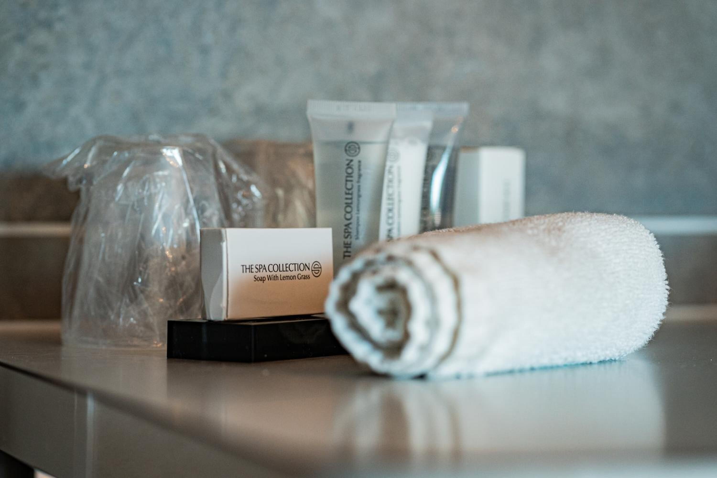 Una caja de productos de spa, una toalla enrollada y una bolsa de plástico sobre una encimera.