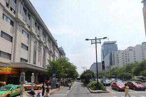 A street view with buildings, a traffic light, and parked cars. - Century Landscape Hotel (Xi'an)