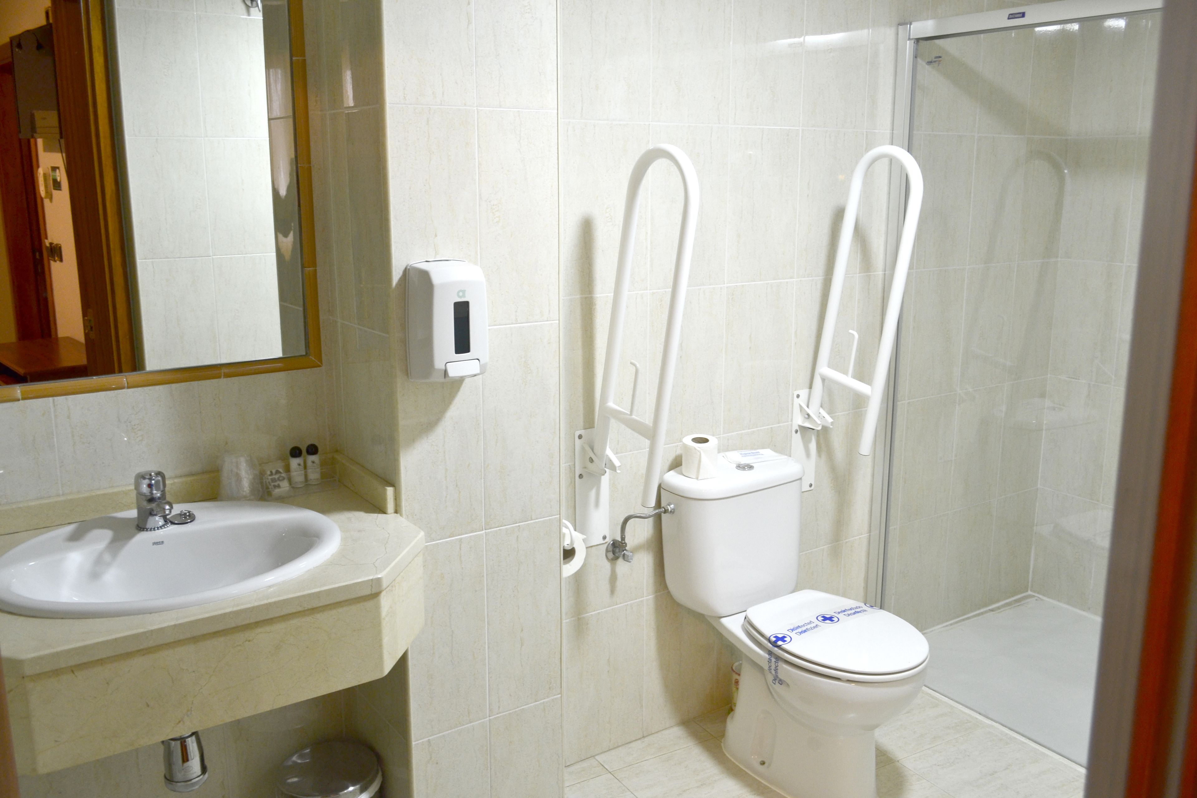 A bathroom with a sink, toilet, and glass shower enclosure.