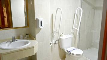 A bathroom with a sink, toilet, and glass shower enclosure.