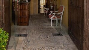 A hallway with a wooden door, a stone archway, and a seating area with chairs. - La Hospederia Del Monasterio (Osuna)