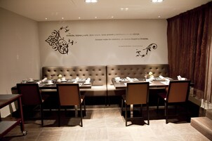 A conference room with a long table, chairs, and a cushioned bench.