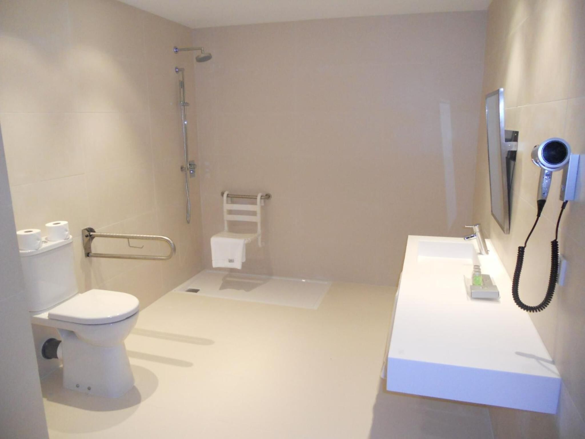 A modern bathroom with a toilet, shower, and sink.