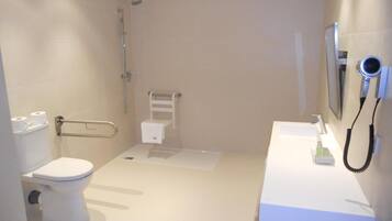 A modern bathroom with a toilet, shower, and sink.