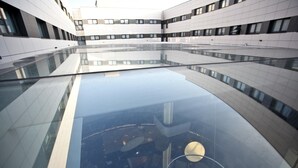 Un edificio moderno con piso de vidrio reflectante y paredes blancas.