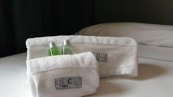 Two white towels with Carris Hotel labels on a bed.