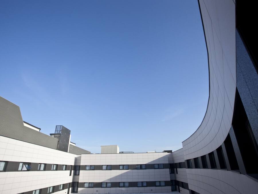 A modern building with a curved facade and multiple windows.