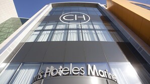 Fachada de hotel con un llamativo logotipo 'CH' y señalización que dice 'Hoteles Marinas'.