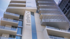 A modern hotel building with multiple balconies, large windows, and a prominent sign. - Aparthotel Adagio Abu Dhabi Al Bustan (Abu Dhabi)