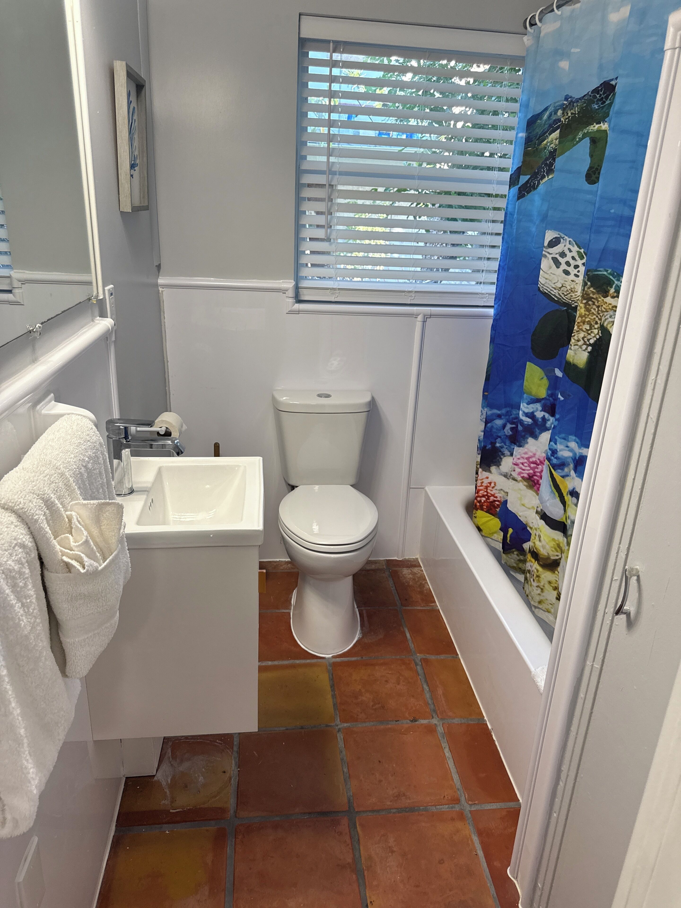 A bathroom with a white sink, toilet, and bathtub.