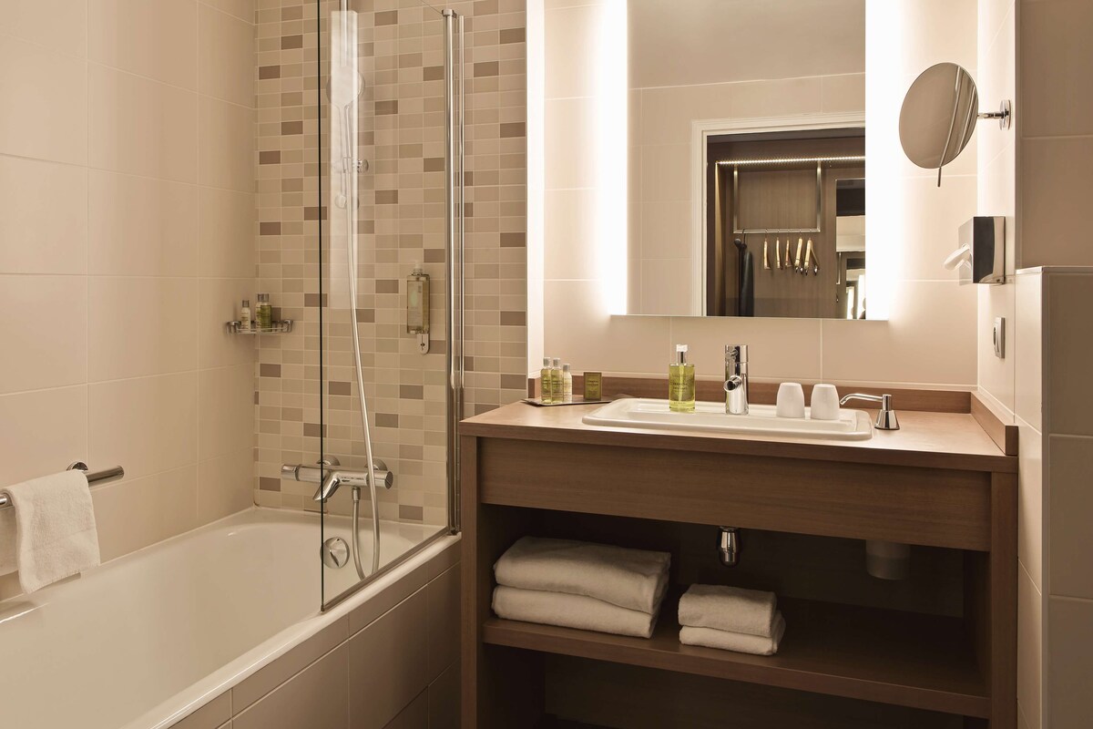 Une salle de bain moderne avec une douche à parois de verre, un meuble-lavabo et un miroir.