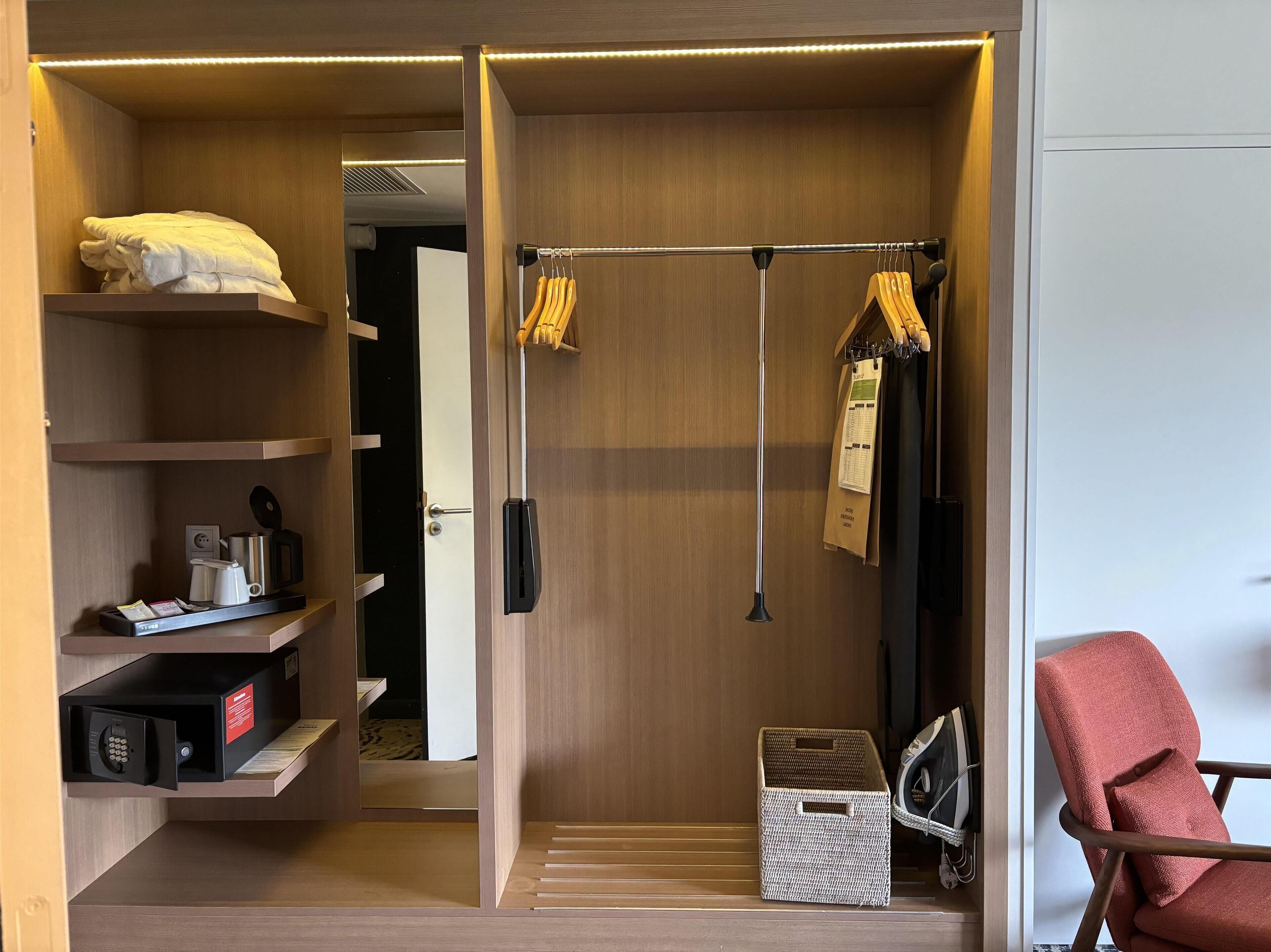 A walk-in closet with a hanging rod, shelves, and a basket.
