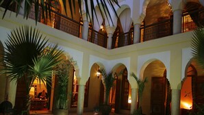 Ein Innenhof mit Pool, Palmen und einer Laterne.