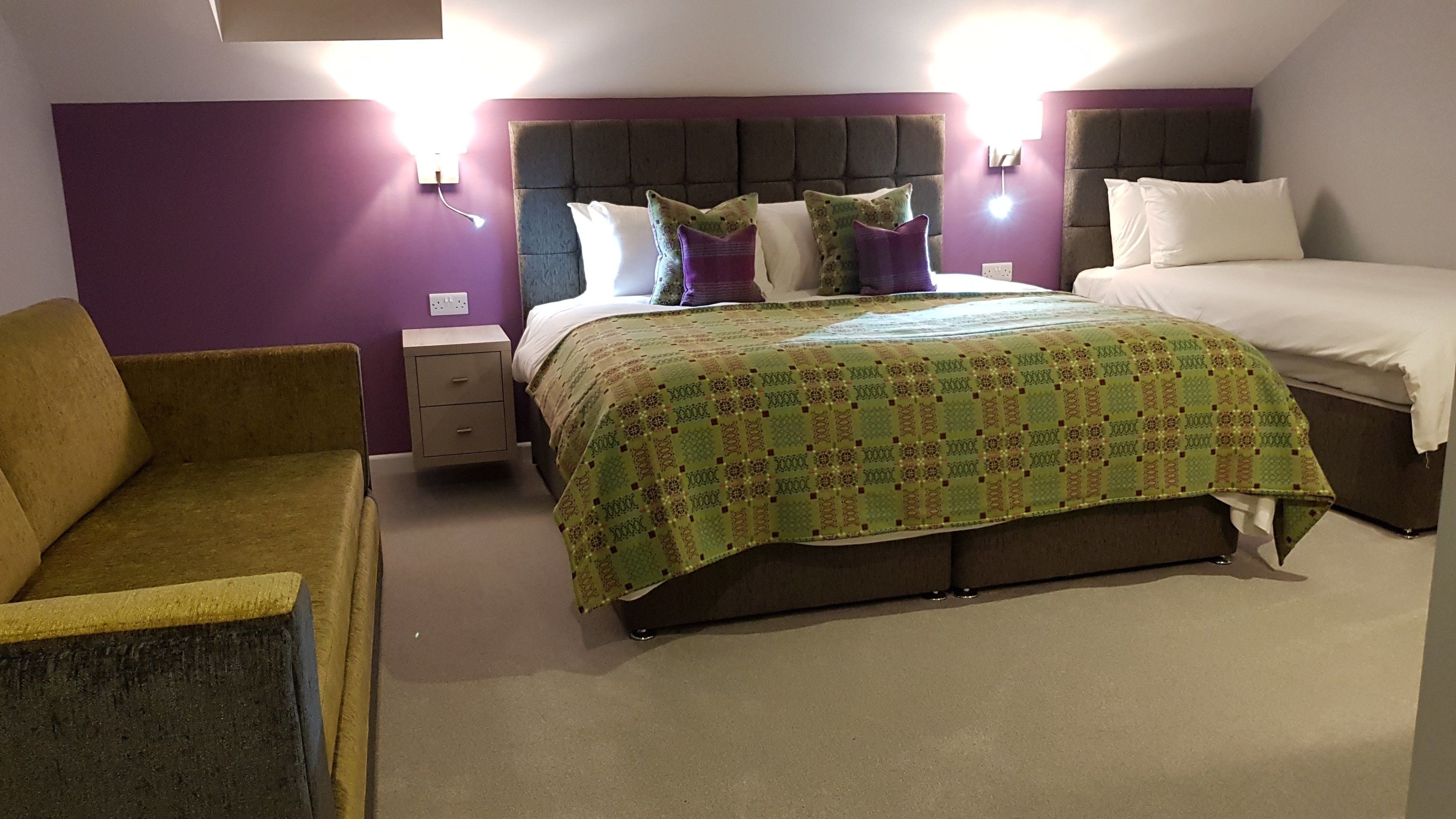 A bedroom with a bed, two nightstands, a chair, and a dresser.