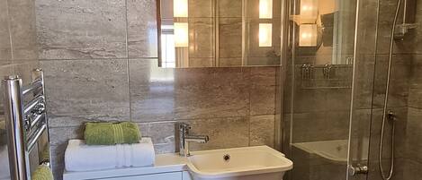 Een moderne badkamer met toilet, wastafel en douche.