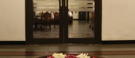 A hallway with a large door leading to a dining area.