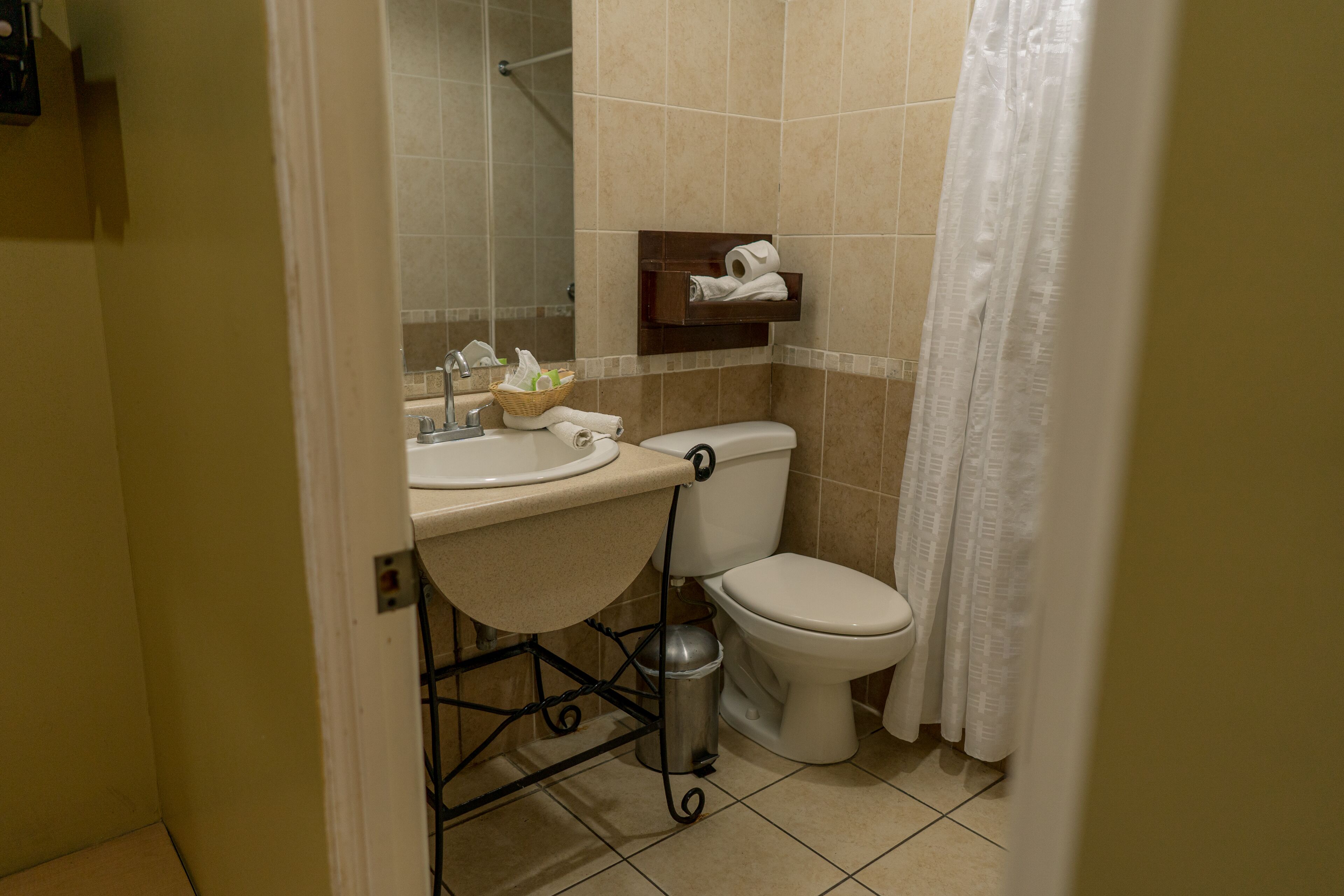 Un baño con lavamanos, inodoro y cortina de ducha.