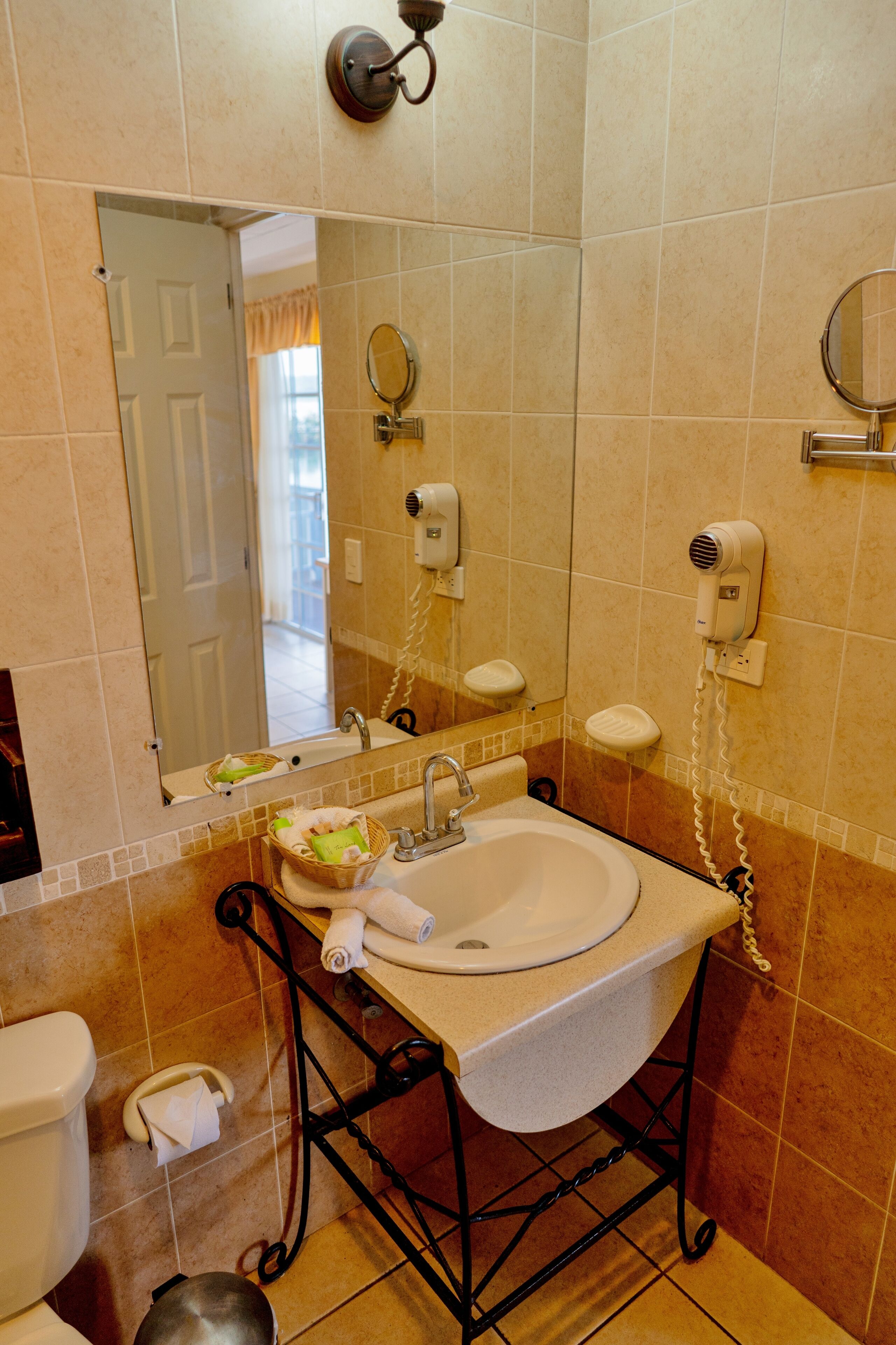 A bathroom with a sink, mirror, and towel rack.