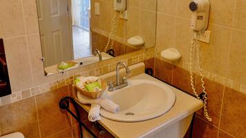 A bathroom with a sink, mirror, and towel rack.