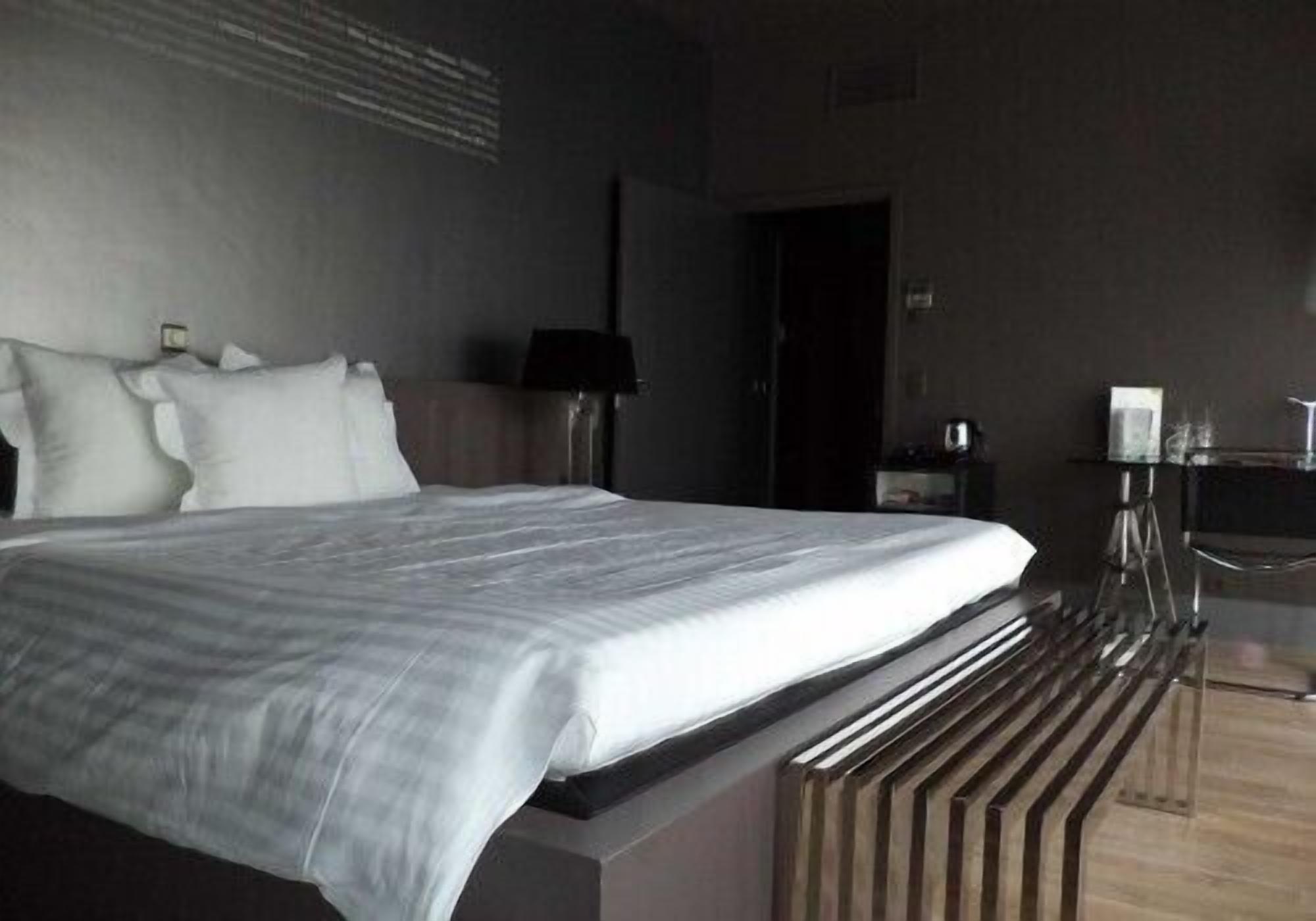 Une chambre d’hôtel moderne, dotée d’un grand lit, d’un bureau et d’une chaise.