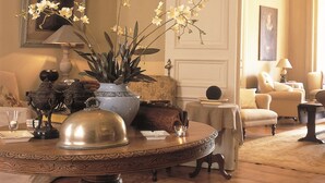 A well-appointed sitting area with a round table, ornate vases, and comfortable seating.