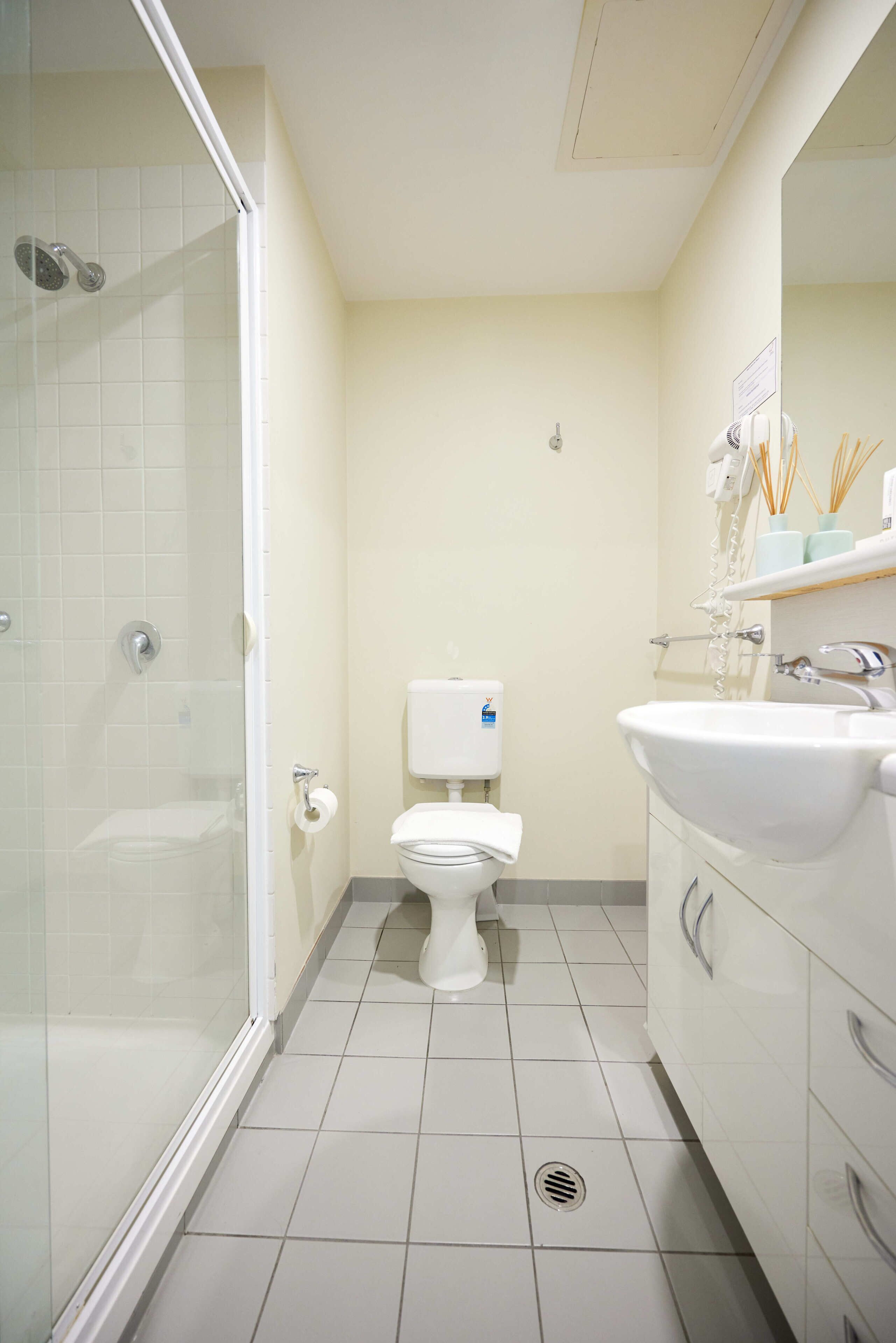 A bathroom with a toilet, sink, and shower.