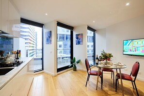 Una cocina moderna con comedor, ventanas amplias y un televisor de pantalla plana.