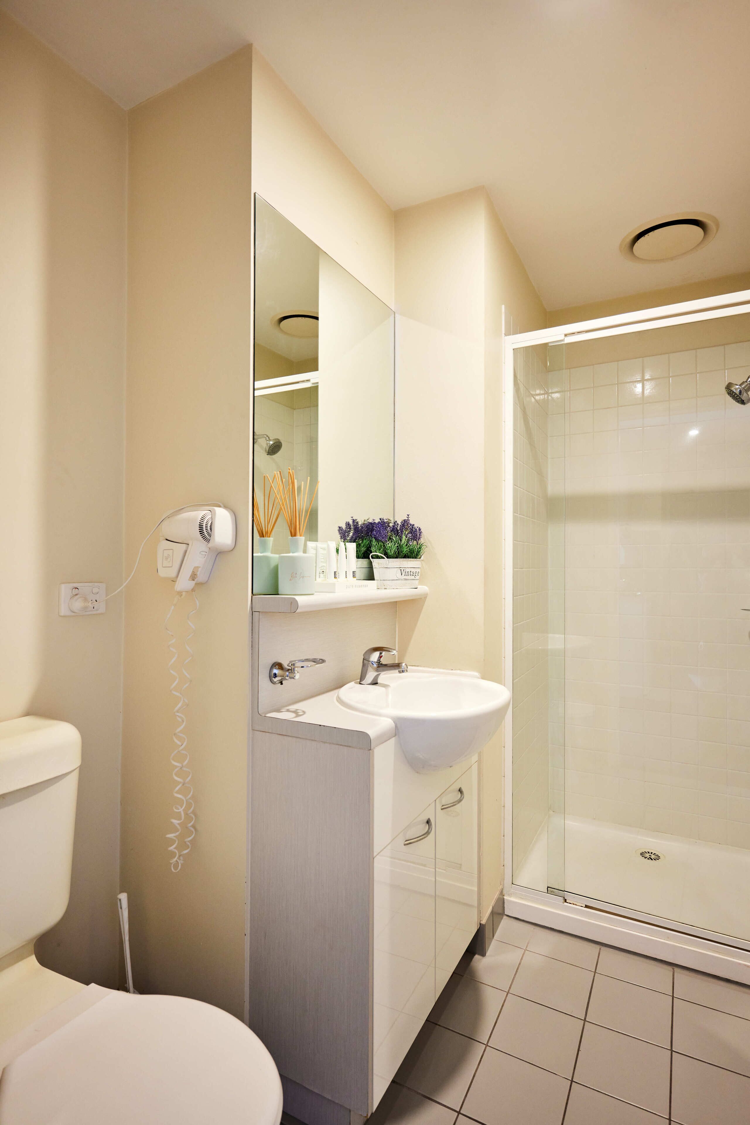A modern bathroom with a toilet, sink, and shower.