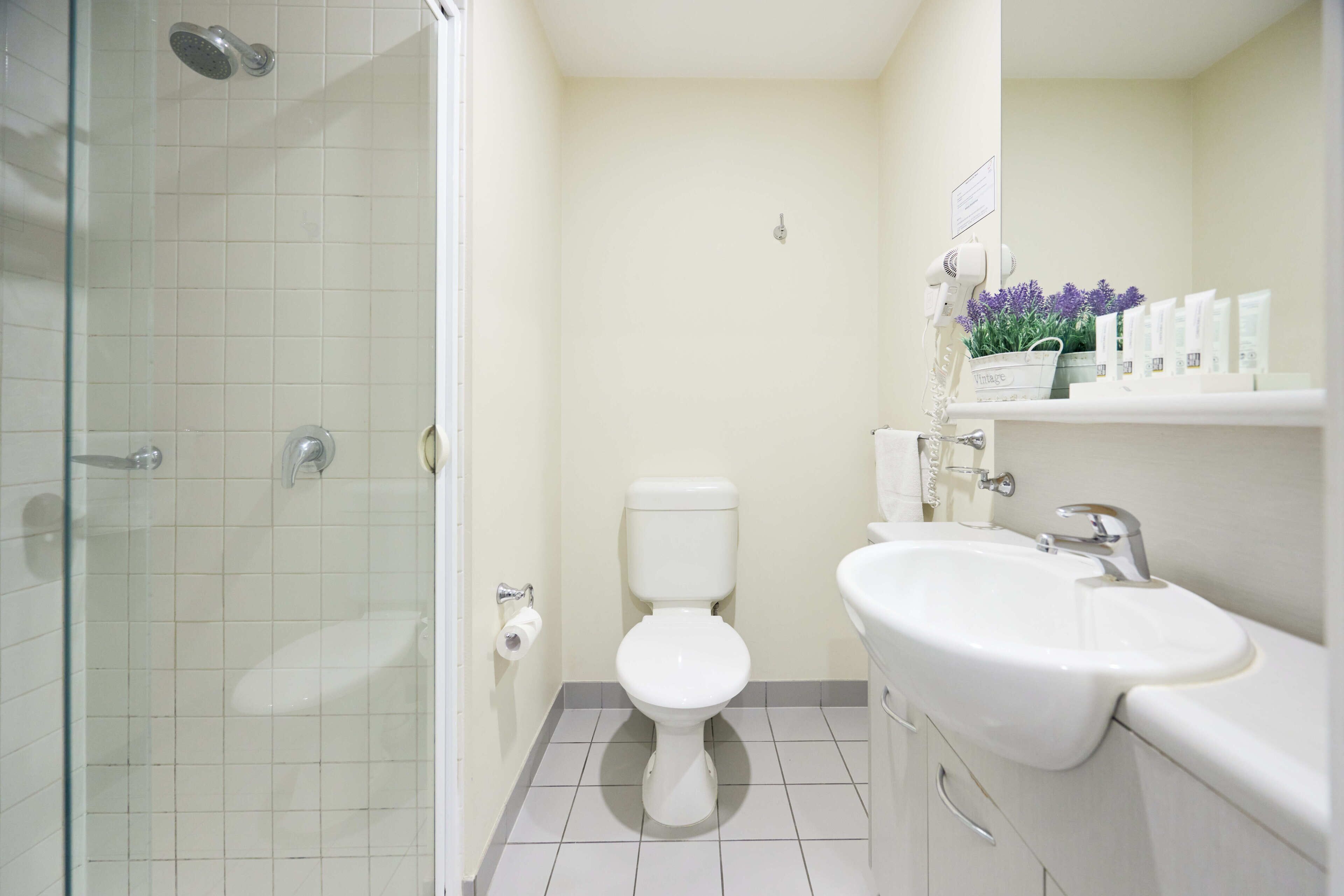 A bathroom with a toilet, sink, and shower.