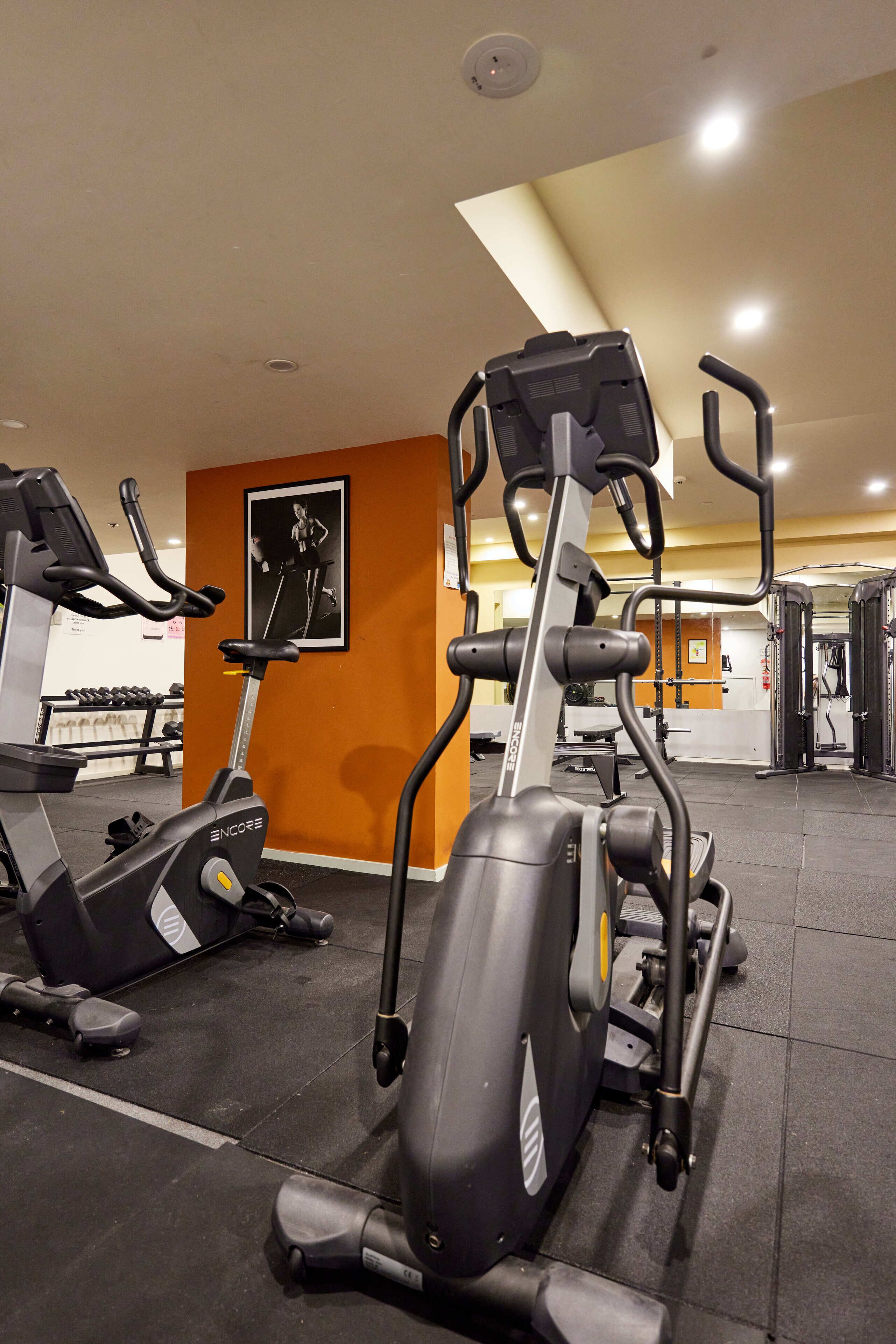 Una palestra con cyclette, tapis roulant e macchinari per l'allenamento con i pesi.