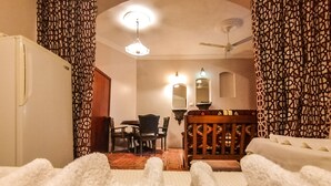 A hotel room with a bed, a desk, a chair, and a dining table. - Ali Baba Hotel (Dahab)